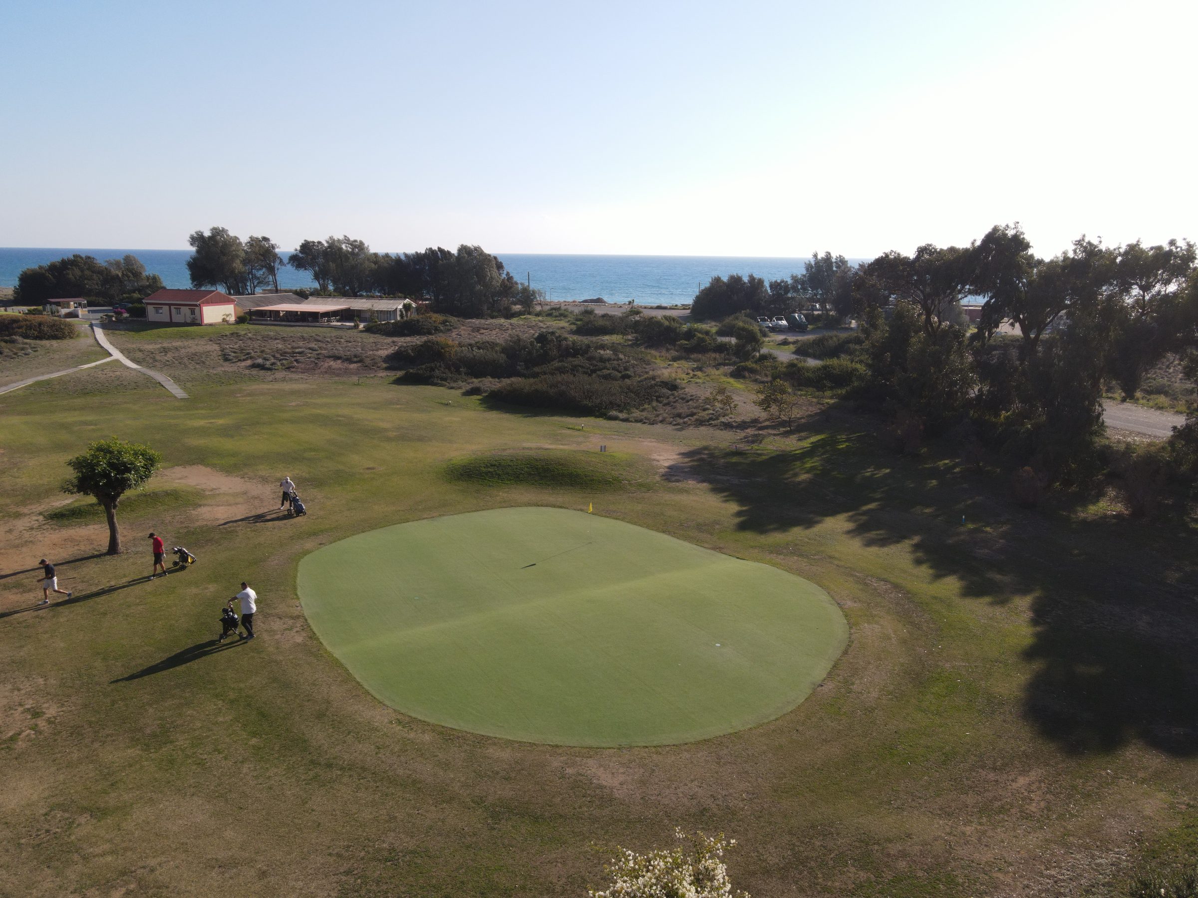 An Astroturf green with the Mediterranean beyond
